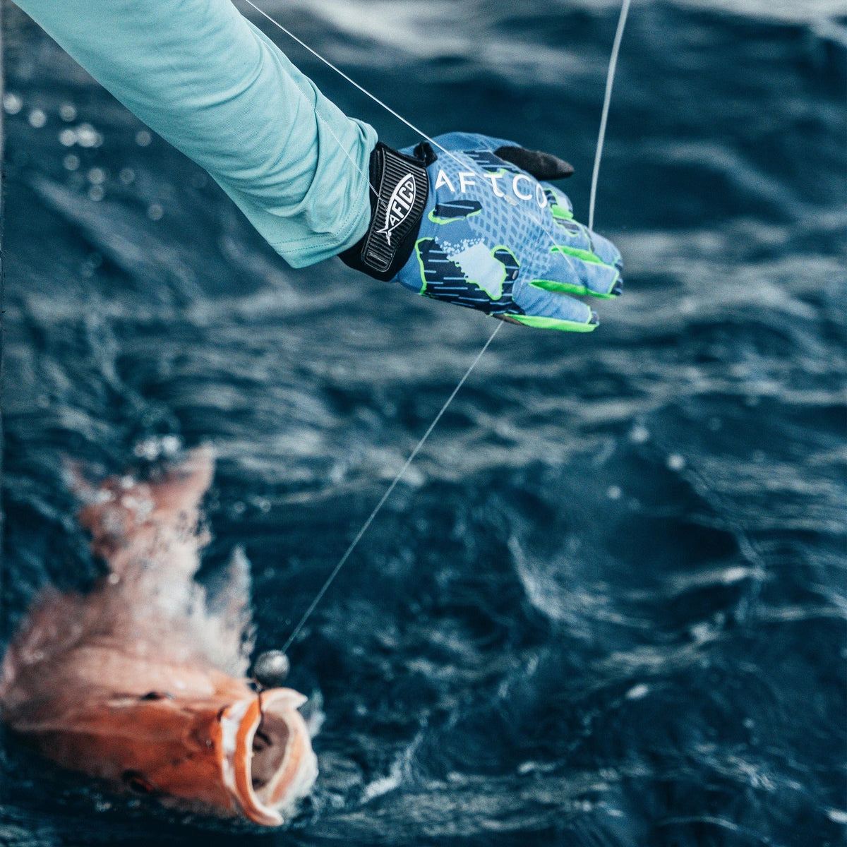 Angler wearing AFTCO JigPro Jigging Gloves while slow pitch jigging